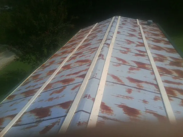 Rusted metal roof panels with new wood purlins before replacement — Storm Damage Roof Repair in Hilliards by Roofing Brothers
